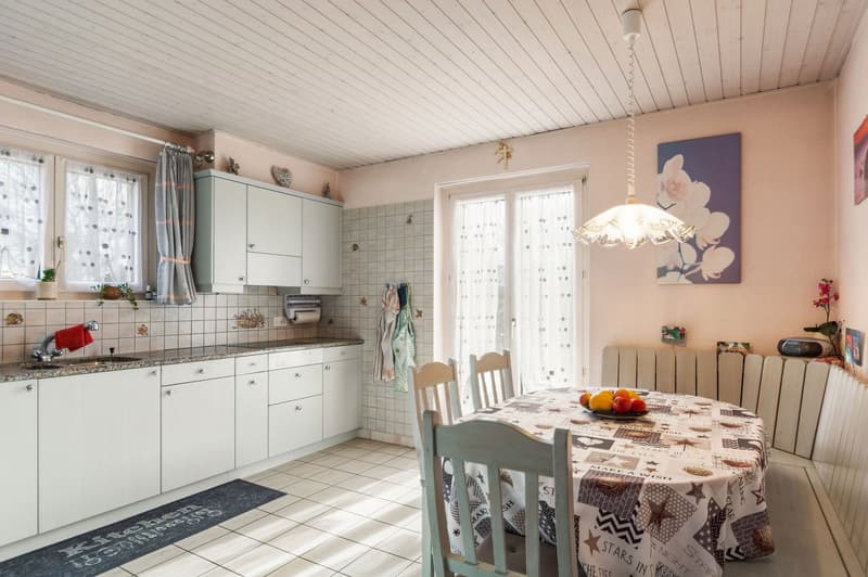 white cabinets, tiled floor, dining table, lamps, window with curtains, sink, faucet