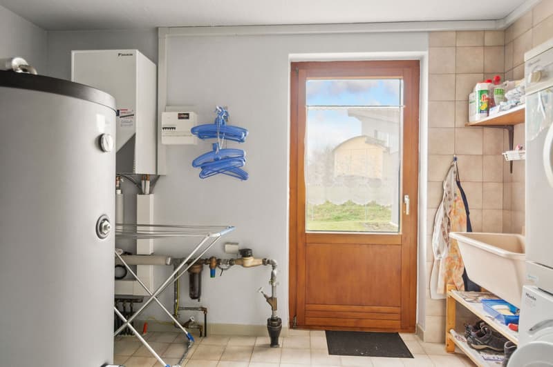laundry area with a washing machine, water heater, pipe and stand, wooden door
