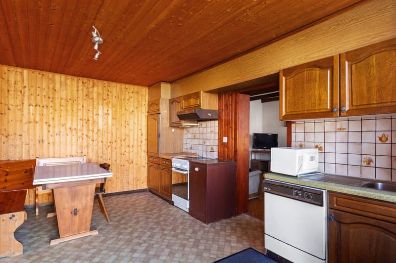 kitchen with wooden cabinets, tiled floor, white appliances, wooden table, microwave, sink, dishwasher, stove