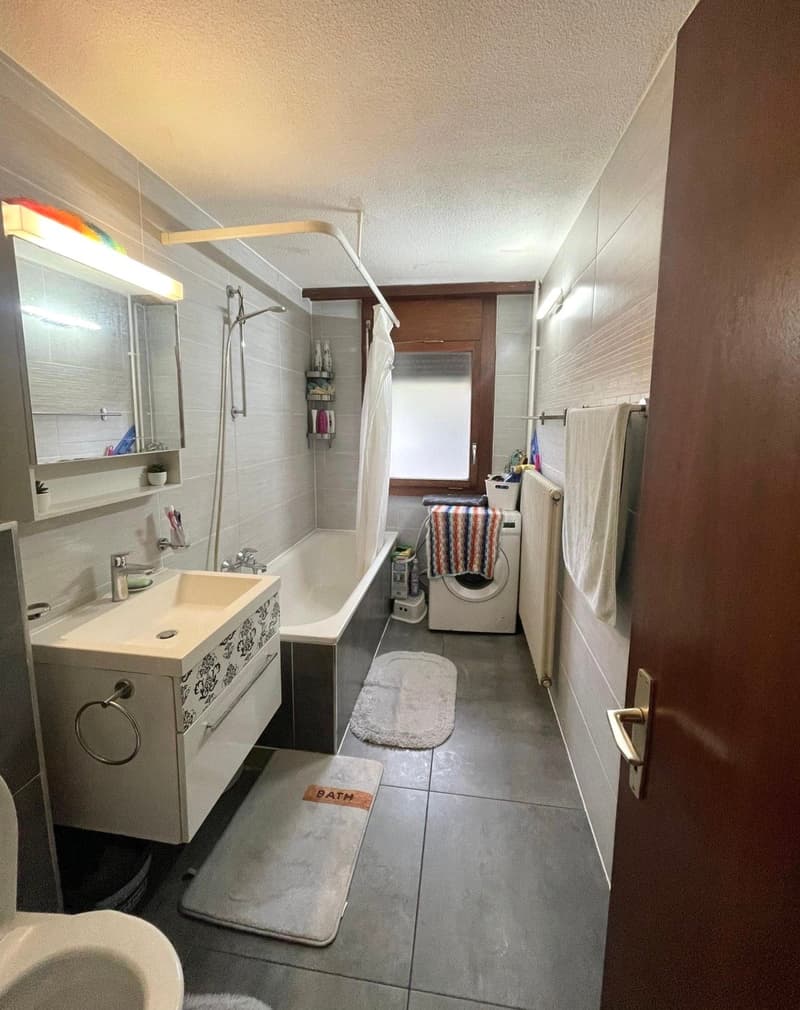 tiled floor, bathtub, shower, sink, toilet, washing machine, radiator, towels, toiletries