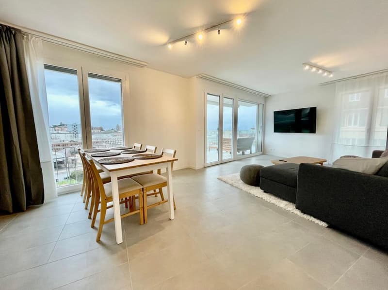 Open living space with sliding glass doors, dining table, sofa, flat screen TV, tiled floor, sliding curtains