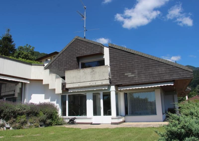 Detached house, two storeys, brown roof, white walls, large windows, balcony, garden, trees