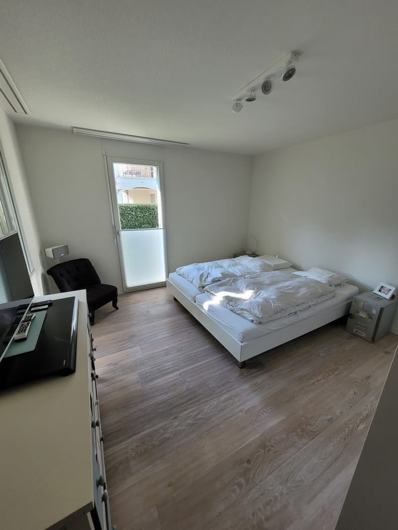 Bedroom with bed, chair, TV, and cabinet