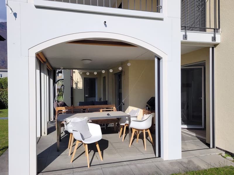 white exterior, covered patio, dining table, chairs, wooden bench, string lights, ceiling lamp