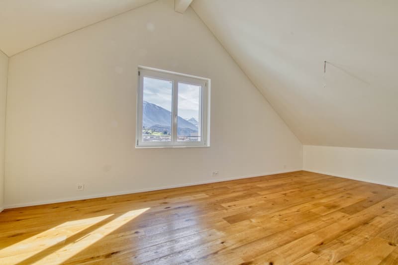Empty room, white walls, hardwood floor, single window, mountain view