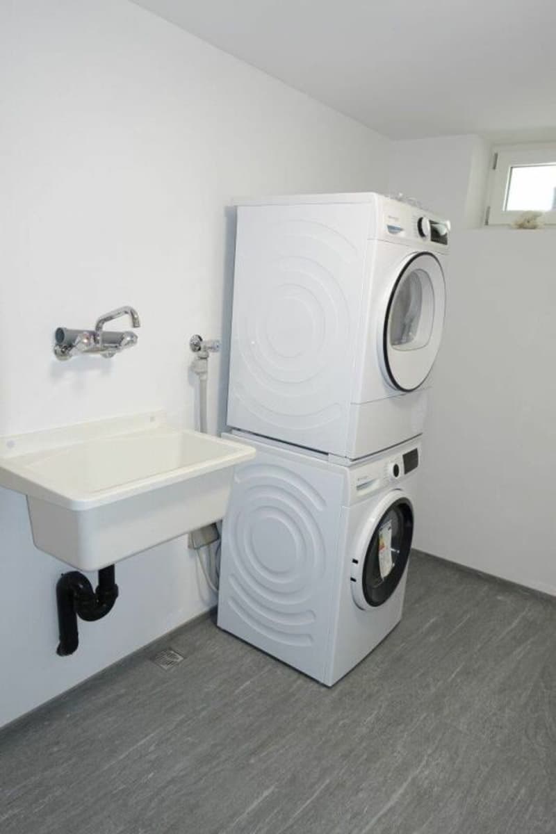 Die eigene Waschküche mit Lavabo, Waschmaschine und Tumbler sowie Trocknungsecke
