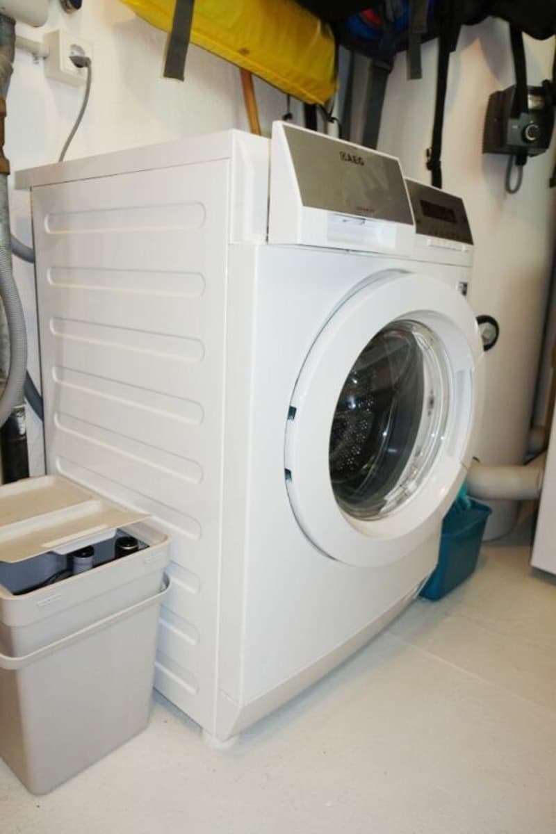 Der Technikraum mit Waschmaschine und Luft-Wärmepumpenheizung.