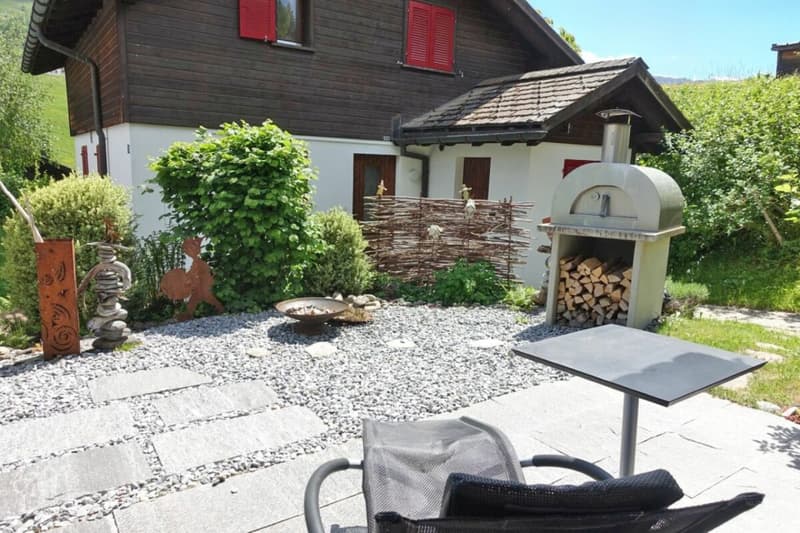 Einer der beiden grosszügigen Gartensitzplätze mit viel Sonnenschein und eigenem Pizzaofen.