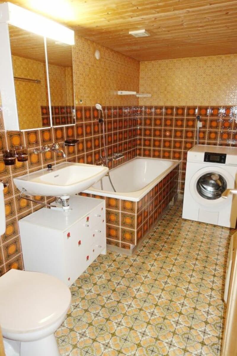 Die Nasszelle mit Lavabo, Toilette, Bad / Dusche und einer Waschmaschine.