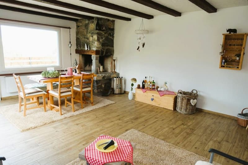 Das Wohnzimmer mit Cheminée und Zugang zum Balkon