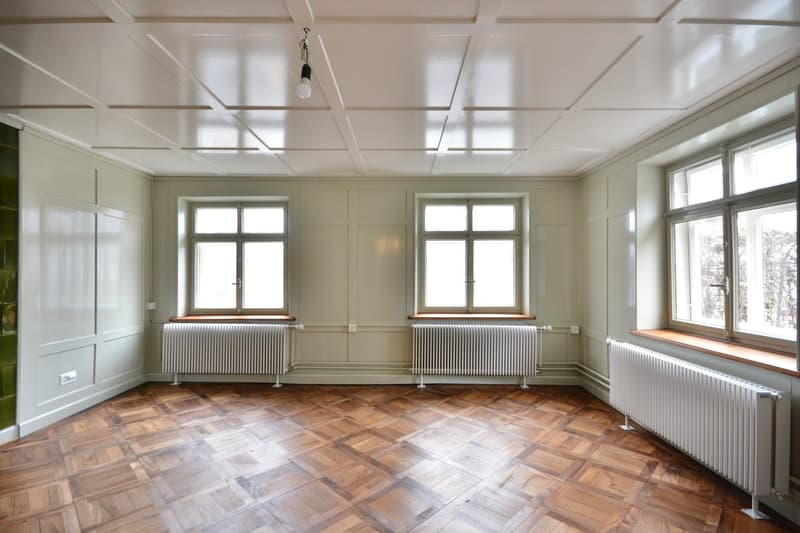 Gemütliches Wohnzimmer mit Kachelofen und Zugang zum Garten