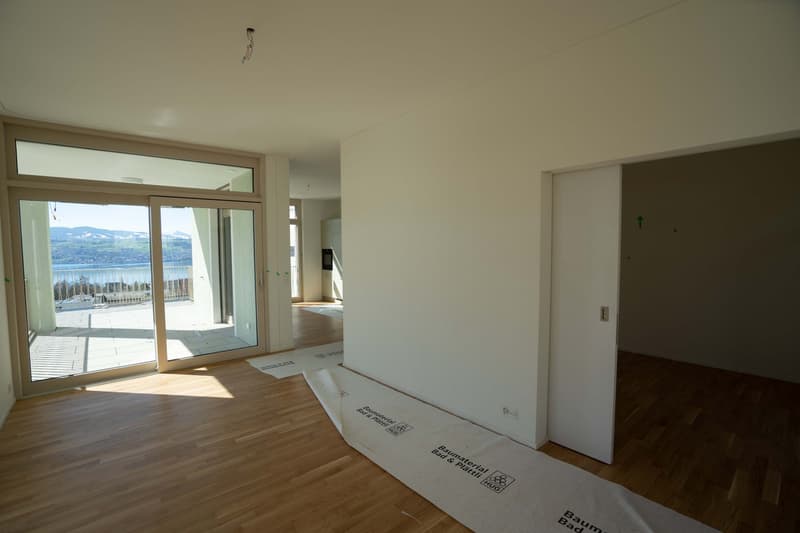 empty room, wooden floor, sliding glass doors, balcony, white walls, power outlet