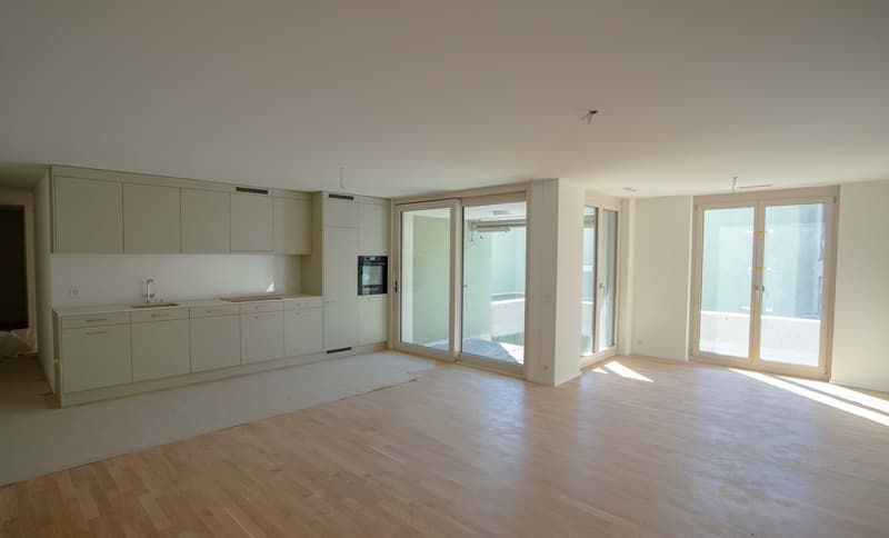 modern kitchen with white cabinets, wooden floor, large windows, balcony