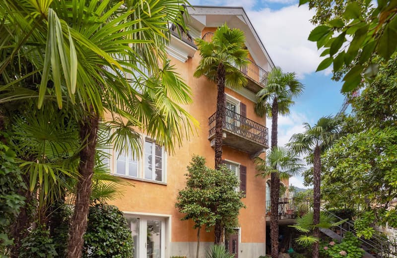 Apartment building, brick wall, glass windows, balconies, staircase, tropical trees, garden
