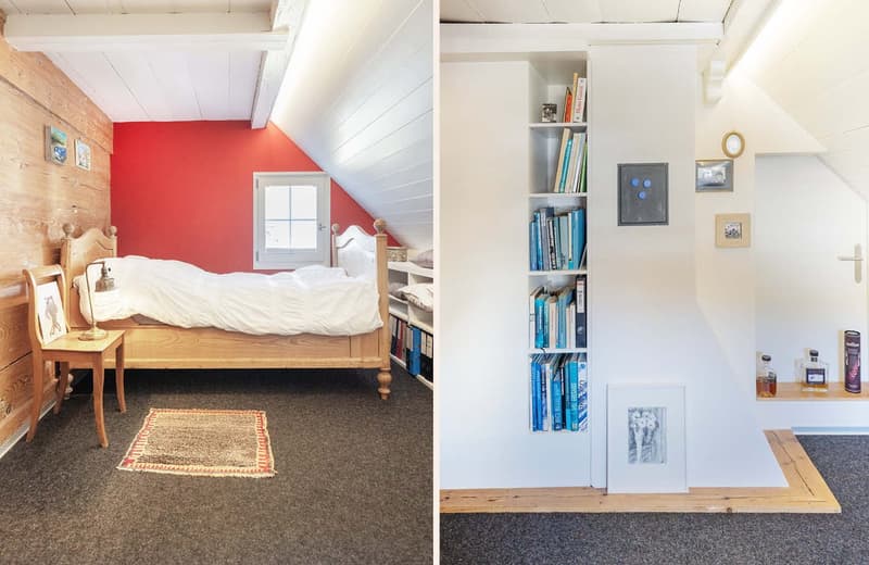 Bedroom with bed, wooden chair, lamp, rug, wooden wall, red wall, window, shelf with books, picture frames, clock, bottles