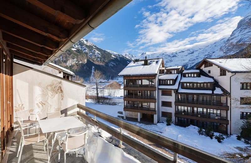Balcony, tables and chairs, snowy landscape, mountains in the background