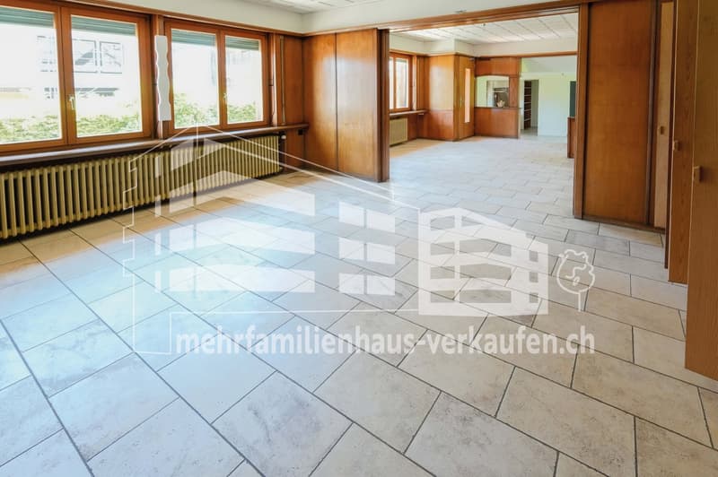 empty room with white tiles, wooden panels, windows, and under-window radiators