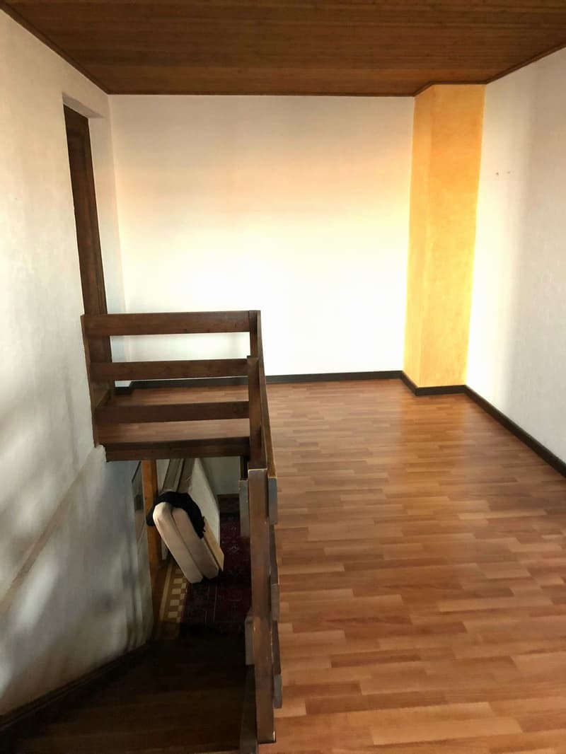 wooden stairs, wooden floor, white walls, yellow column