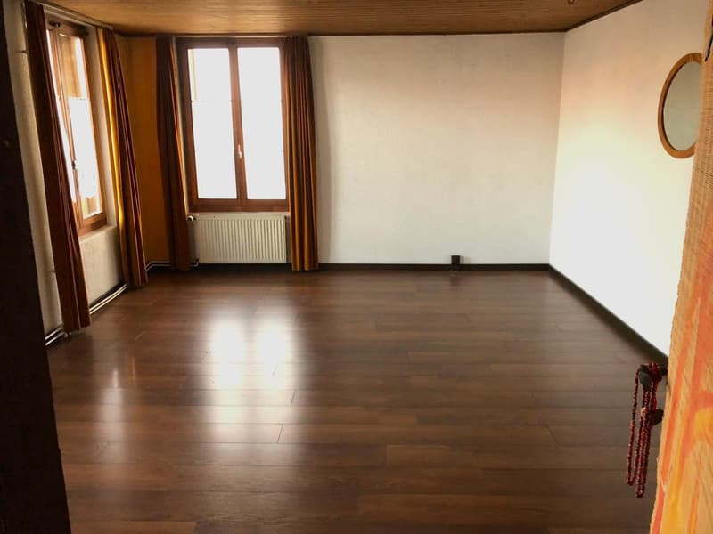 empty room, wooden floor, white walls, two windows, curtains, radiator, mirror