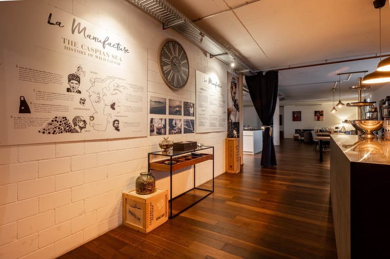 white brick wall, wooden floor, large clock, display table, decorative items, black curtain