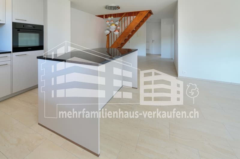 modern kitchen with island, white cabinets, tiled floor, wooden staircase, chandelier