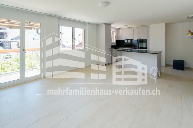 Open plan living room and kitchen, large windows, balcony, tiled floor, modern kitchen appliances