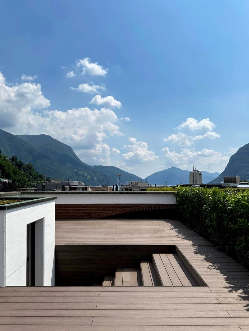 wooden floor, sunken seating area, green rooftop, mountain view