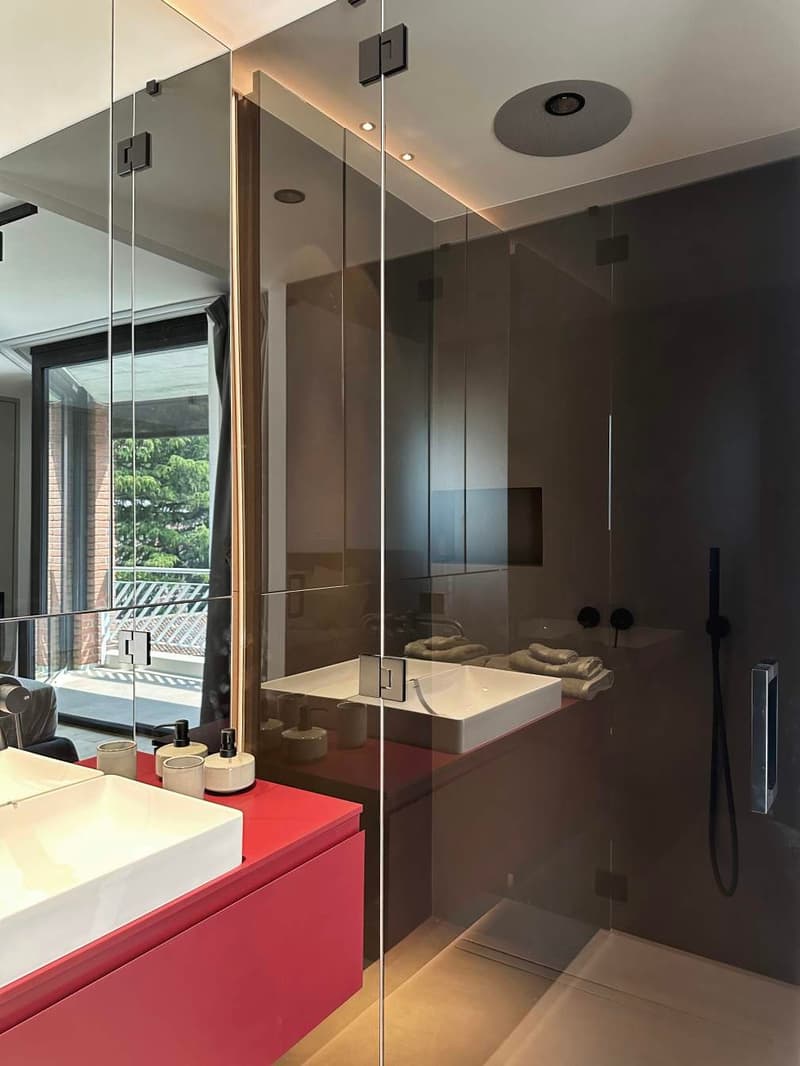 modern design, glass walls, red wooden vanity, white sinks, glass shelves, ceiling light