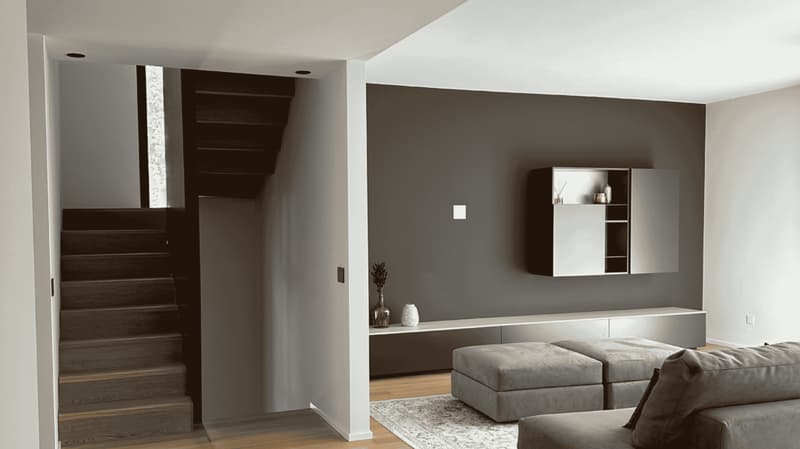 gray walls, built-in shelf, staircase, hardwood floor, leather sofa, rug, ottoman