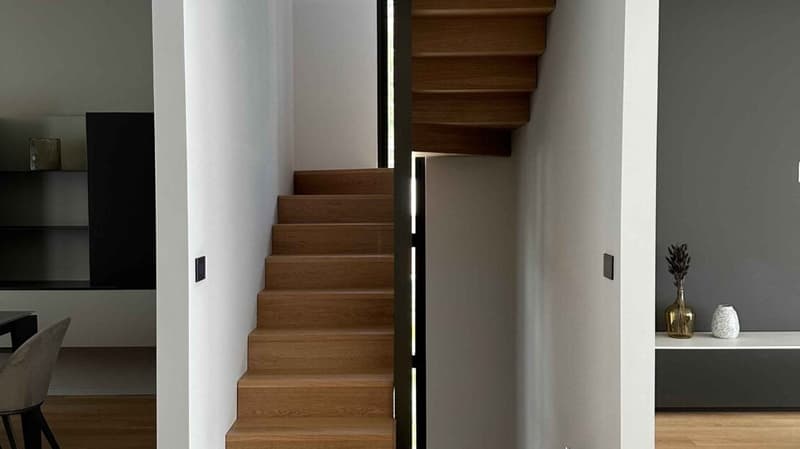 wooden staircase, white walls, hardwood floor, modern furniture, shelf