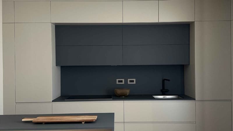 modern kitchen with black stove, faucet, sink, and wooden bowl
