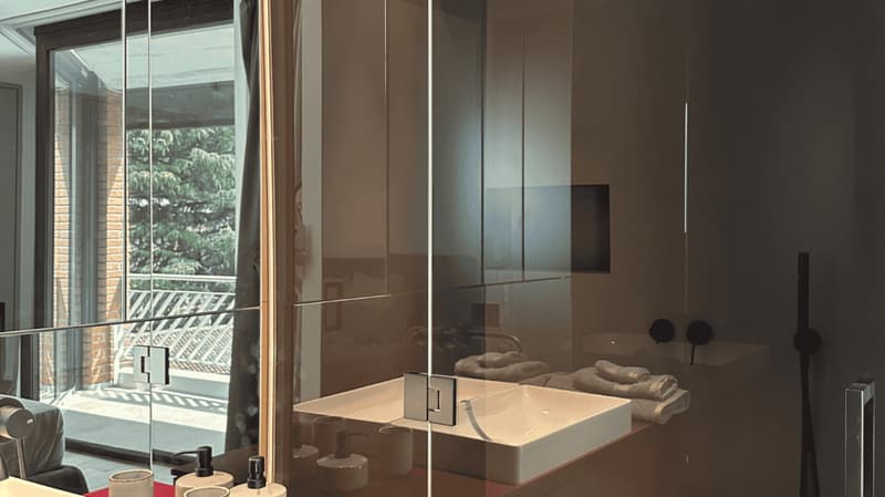Sliding glass door, glass wall, modern white sink, toilet bowl, towel rack, balcony, window