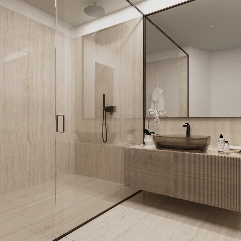 Minimalist style bathroom with beige wall tiles, glass shower enclosure, curved vanity with round basin, white towel rack, and flowers in a vase