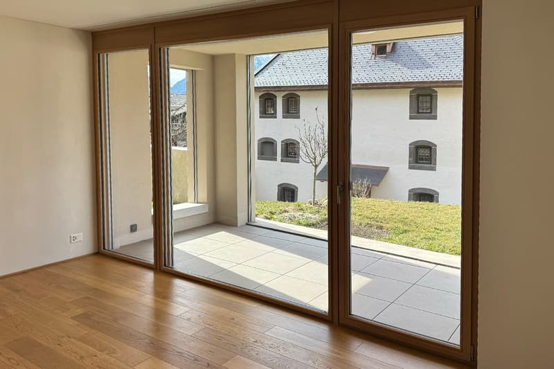 Floor room with wooden floor and glass sliding doors to terrace with a grassy area outside