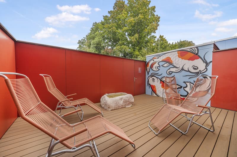 wooden deck with sun loungers, outdoor seating area, red walls, mural, koi fish painting