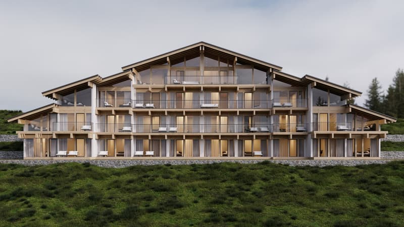 Modern building with large glass windows, wooden balconies, and multiple floors. Surrounded by green landscape.