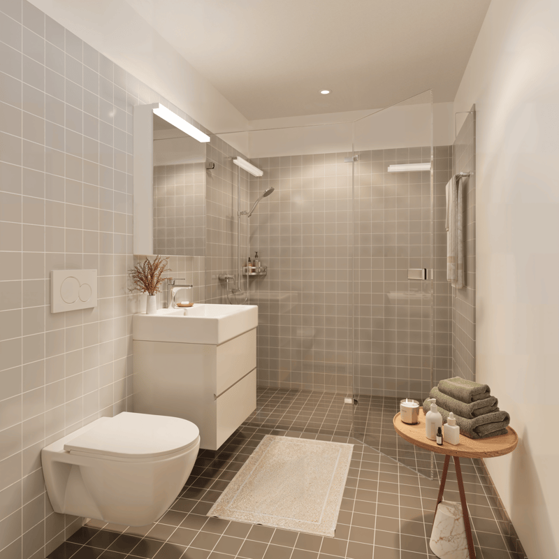 Modern bathroom with white tiles, white toilet, white sink, glass shower enclosure, white towel, white rug, wooden table with towels, candles, and bottles