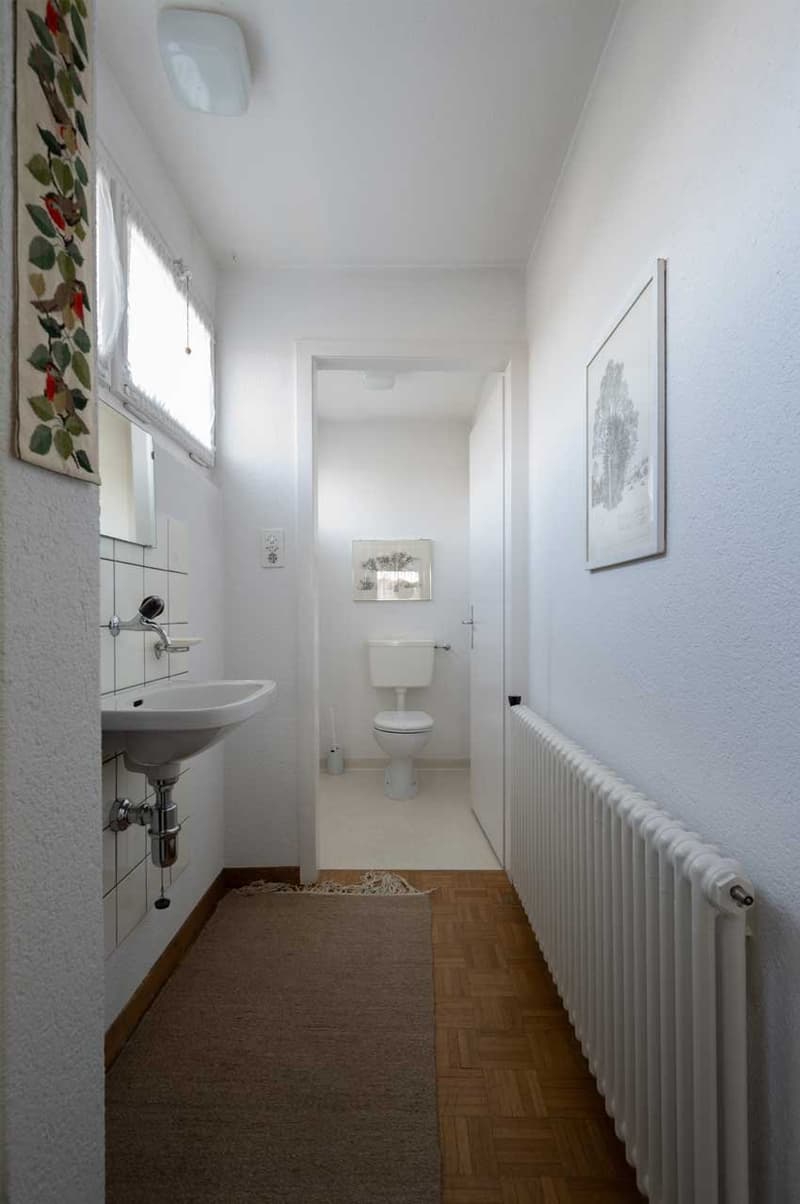 single sink, toilet, white tiles, white radiator, tiled floor, picture frame, mirror, radiator, toilet bowl