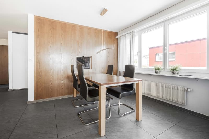 wooden wall, wooden table, four chairs, wooden flooring, radiator, white window curtains, window