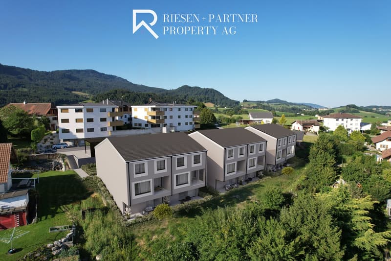 Apartment buildings, multiple stories, balconies, surrounded by greenery, mountains in the background