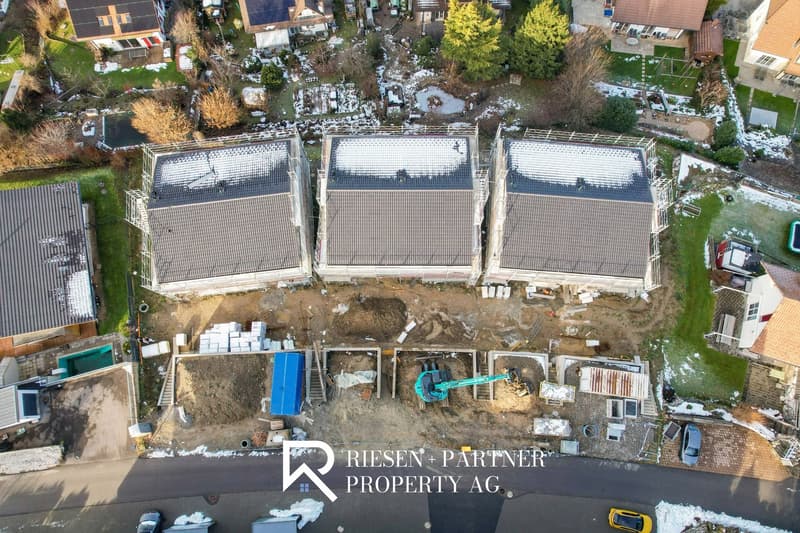 Houses under construction, multiple buildings, rooftops, construction equipment