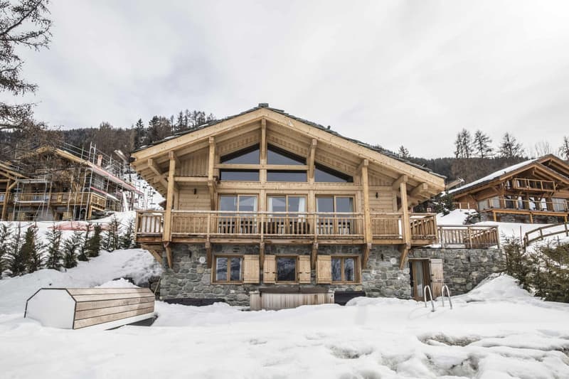 log chalet with wooden balconies, stone foundation, wooden interior, nestled in snowy mountainous landscape