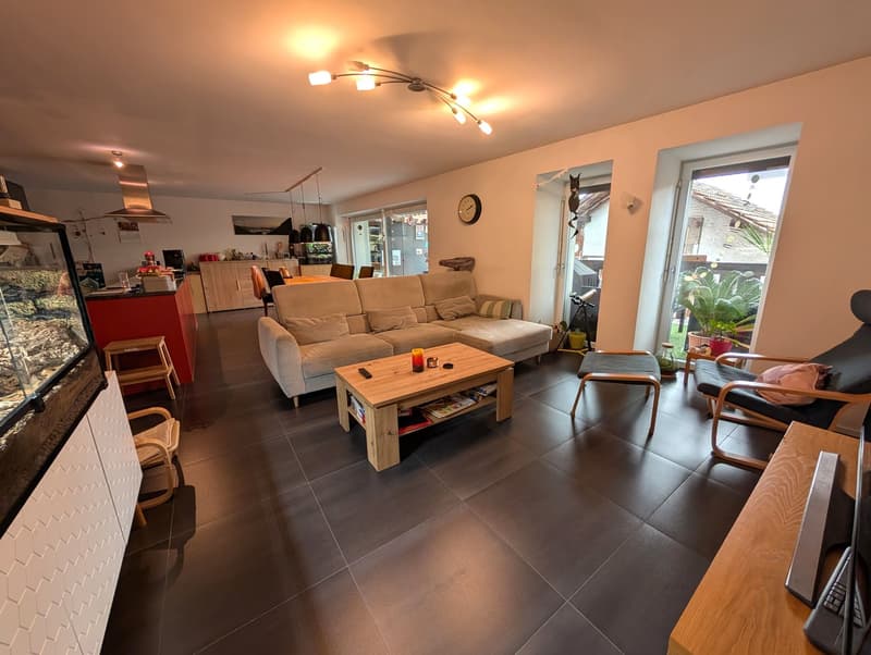 large living room with grey couch, coffee table, wooden table with keyboard, stools, aquarium
