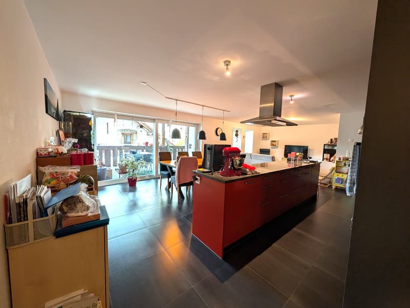 kitchen with dining area, island with stove, refrigerator, and a blender, cabinets, dark floor and windows