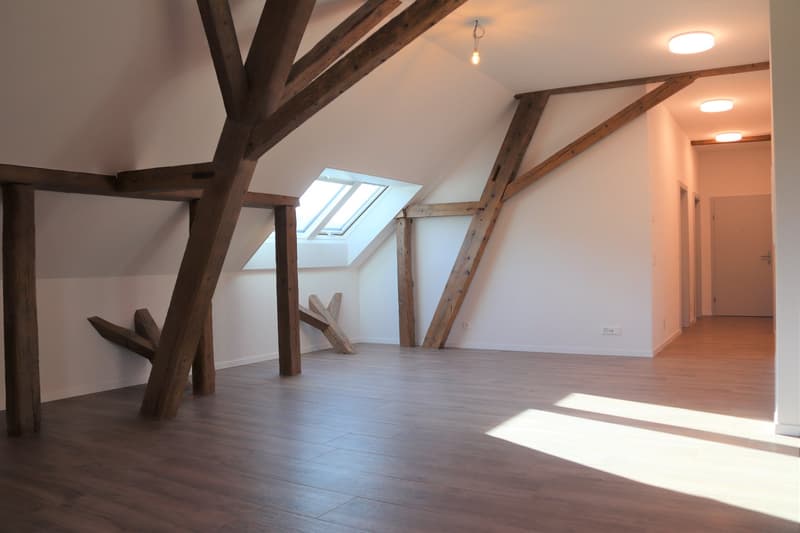 empty attic with wooden beams, skylights, and wooden floors.