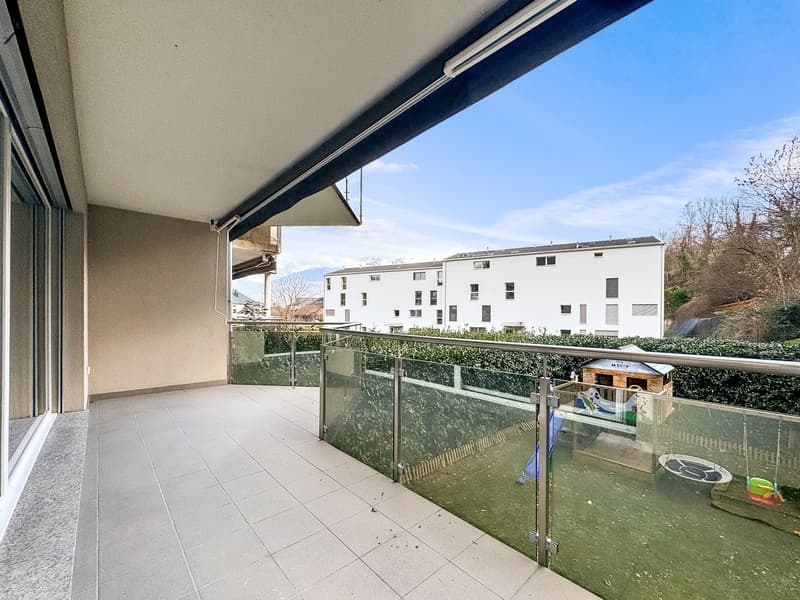 tiled floor, glass railing, views of the building, green bush