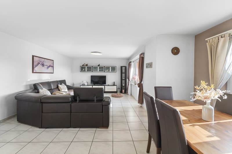 modern, minimalistic design, L-shaped brown leather sofa, wooden table, dining chairs, tiled floor, modern furnishings, window with curtains