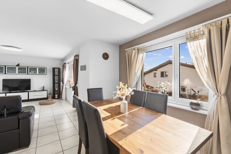 dining area with wooden table, chairs, and windows with views