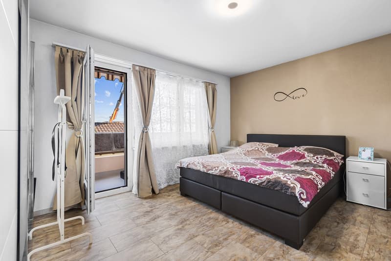 bedroom with a double bed, wardrobe, nightstands, and a door leading to a balcony