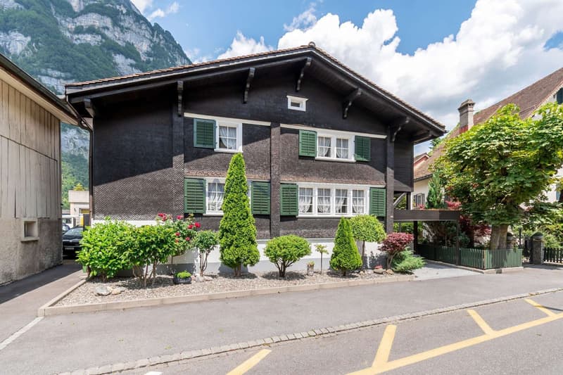 Chalet vor steiler Felswand
